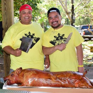 President Leon Florendo and Andre Mejia of Toronto, Canada prepare to cut up the lechon.